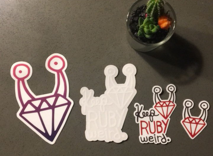 Four different Keep Ruby Weird stickers layed out on a table with a succulent