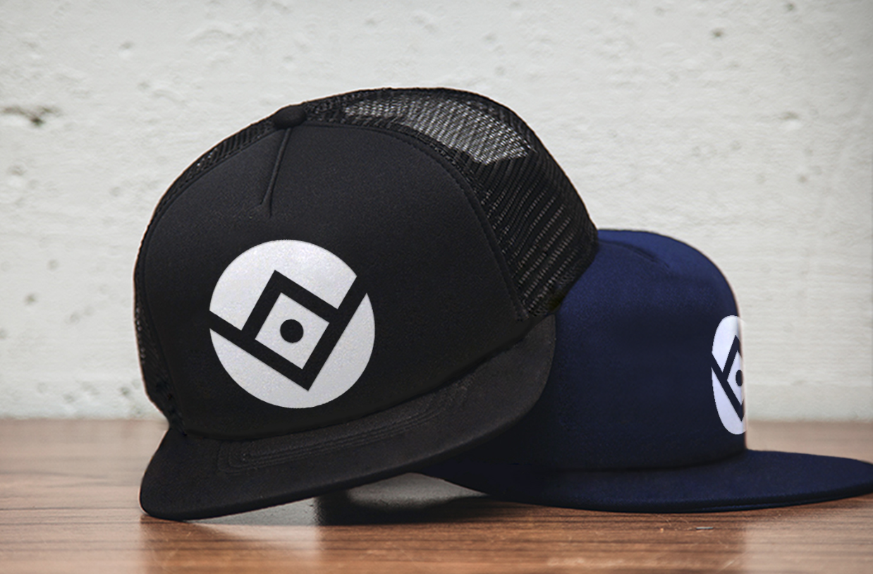 A black trucker hat and a blue hat with the Ottoneu logo mark on them